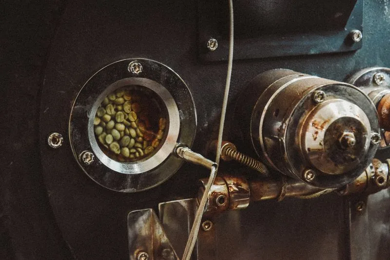 Green coffee beans inside a small-batch roasting machine